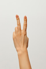 Fototapeta premium Lady`s hand shows two fingers meaninf 