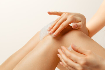 young woman applying cream on her body