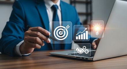 Businessman points at virtual target, chart, handshake and lightbulb icons on a laptop screen representing business goals and success.