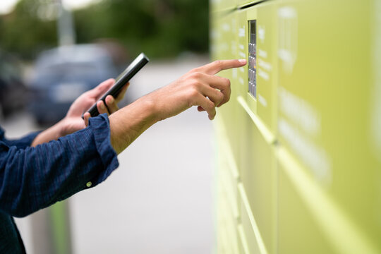 Young adult retrieves package from parcel locker, mailbox