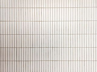 close up image of white white ceramic wall tiles use as background with blank space for design. interior wall finishing material. metro tiles background. subway brick in vertical pattern.