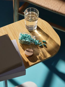 Pills and water on a wooden table, promoting health and well-being