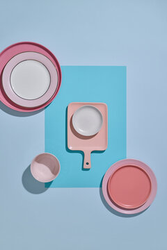 Pastel plates and bowls arranged on a blue background