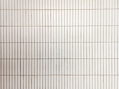 close up image of white white ceramic wall tiles use as background with blank space for design. interior wall finishing material. metro tiles background. subway brick in vertical pattern.