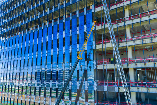 High rise building construction with cranes and glass facade