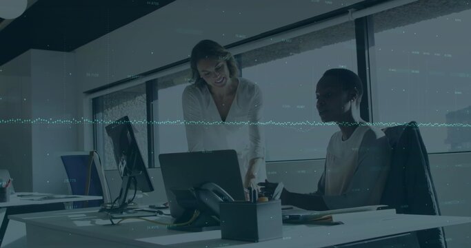 Typing business casual women collaborating at modern office desk, with laptop and smartphone