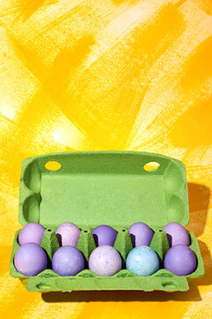 Colorful easter eggs displayed in a green carton