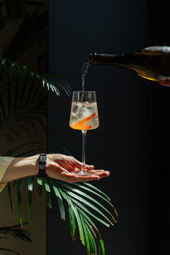 Sparkling cocktail poured into wine glass with orange twist