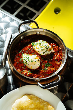 Shakshuka with poached eggs in metal pan