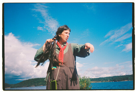 Person gesturing during outdoor speech by a scenic waterway