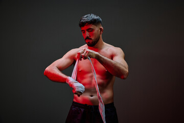 Boxer preparing for training session in dimly lit gym