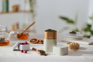 A peaceful tea scene featuring tea tins and dried herbs