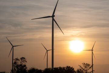 Aerial view of powerful Wind turbine farm for energy production on beautiful sunset sky at highland. Wind power turbines generating clean renewable energy for sustainable development green energy.