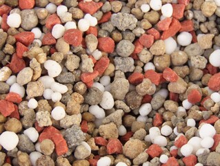 Closeup of granular fertilizer for plants known as NPK, or a combination of nitrogen, phosphorus and potassium, over a wooden background. Gardening concept. Fertilizer for plants.