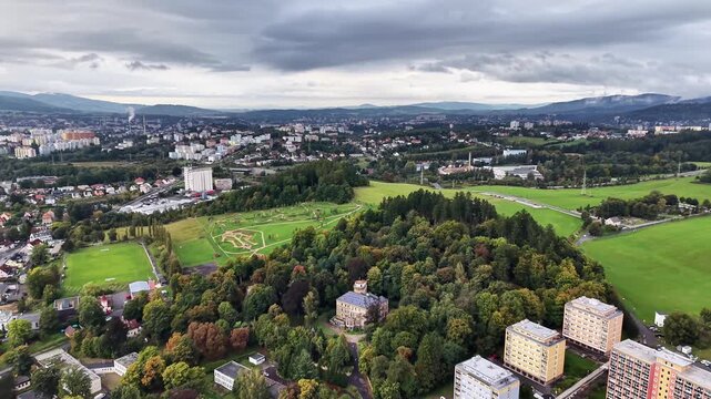 An aerial view captures a vibrant landscape with lush parks amidst urban residences and tall buildings