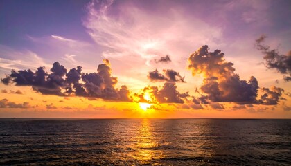 Sunset over calm ocean, vibrant clouds