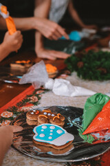 An overhead view of a board displaying Christmas gingerbread cookies baked by children during a holiday workshop. Children baking party. Preparing for New Year and Christmas.