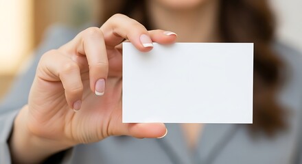 Businesswomans hand holding blank business card with focus on white card, and corporate meeting.