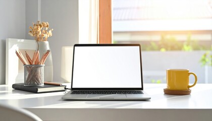 Fototapeta premium Modern workspace with laptop, stationery, and coffee cup, illuminated by morning sunlight