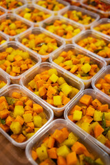 Indonesian acar kuning, yellow pickles made with carrot, potato, and beans cooked with turmeric and spices, packed in plastic containers for catering or food delivery