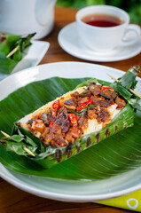 Grilled rice with fried potatoes and liver, wrapped in banana leaves, a traditional Indonesian dish