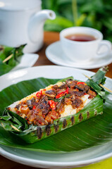 Grilled rice with fried potatoes and liver, wrapped in banana leaves, a traditional Indonesian dish