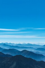 Serene view of blue mountain ranges fading into the misty distance under a clear sky, capturing natural beauty, tranquility, and peaceful atmosphere of layered mountain landscapes.