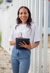 retrato de mujer empoderada con tableta en mano y ropa casual