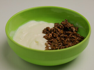 Yogurt and chocolate granola in green bowl