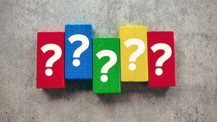 Vibrant Question Marks on Colorful Wooden Blocks on a Grey Background Representing Problem Solving and Doubt