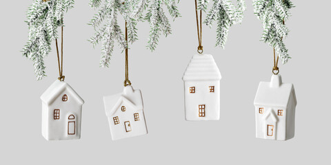 Set Small houses Christmas bauble hanging on snow green branches on gray background, New Year decor as symbol of estate, mortgage, insurance, new home,  and cozy holiday, minimal style winter banner