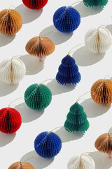 Minimal pattern of colorful paper Christmas ornaments shaped round balls and Christmas tree, stylish holiday photo. Festive Geometric texture of paper Honeycomb baubles. Christmas and New Year concept
