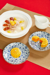 Chinese Dessert with Taro, Ginkgo, and Mooncake on Red Table for Mid-Autumn Festival