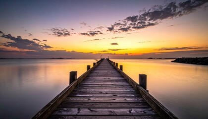 Obraz premium Sunset Above Calm Sea and Wooden Pier Silhouette under Evening Light with Colorful Sky and Dramatic Clouds in Tranquil Scenery for Travel and Nature Adobe Stock