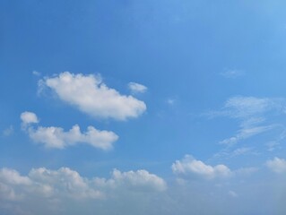 clear blue sky with a few clouds. The sky is very bright and the clouds are scattered throughout	