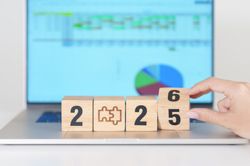 Obraz na płótnie Canvas 2025 end year to Happy New Year 2026 block with jigsaw puzzle icon against laptop computer. Business Process, Team, teamwork, Goal, mission, Resolution, strategy, plan, Action and partnership