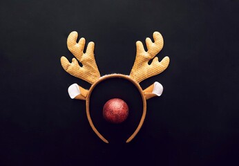 A festive reindeer headband with golden antlers and a red nose, set against a dark background. Perfect for Christmas celebrations and holiday parties.