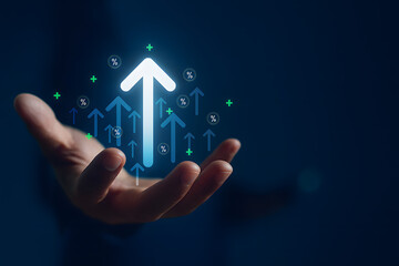 Businessman holding virtual glowing upward arrow icon, symbolizing business growth, financial performance, investment success, and positive economic trends with percentage signs