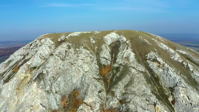 An aerial drone shot captures the breathtaking natural beauty of Shihan Toratay, a unique geological formation in the South Ural region of Russia. The footage showcases the hill's rugged, rocky slopes