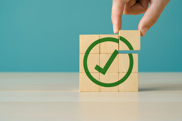 Corporate regulatory and compliance concept with wooden cube showing green checkmark, symbolizing goals achievement, ethical business, quality assurance, and ISO standards