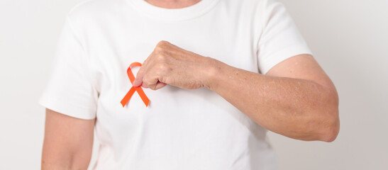 Elderly with Orange Ribbon for September Leukemia, March Kidney cancer day, Multiple Sclerosis, November Complex Regional Pain Syndrome, CRPS, COPD, Chronic Obstructive Pulmonary disease concepts