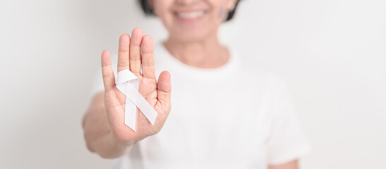 Elderly with White ribbon for concept November Lung Cancer Awareness month, Stop Violence Against Women, Adoption, May Retinoblastoma, Action for Women Health, March Remembrance, October Osteoporosis