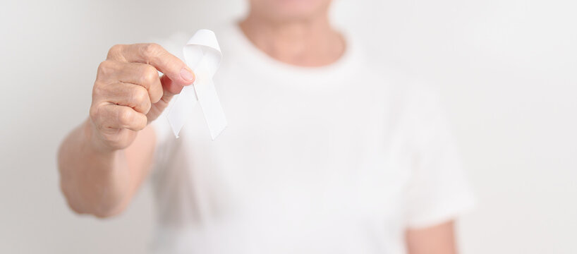 Elderly with White ribbon for concept November Lung Cancer Awareness month, Stop Violence Against Women, Adoption, May Retinoblastoma, Action for Women Health, March Remembrance, October Osteoporosis