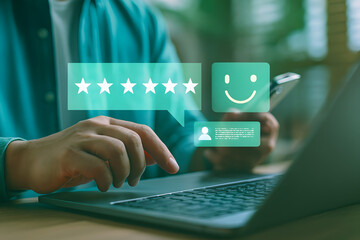 Close-up of hands using laptop and smartphone with floating five-star rating and feedback icons, symbolizing online reviews, customer satisfaction, service ratings, and digital user experience