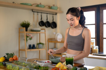 Fitness woman making a wholesome yogurt bowl with fresh fruits and granola for a healthy meal