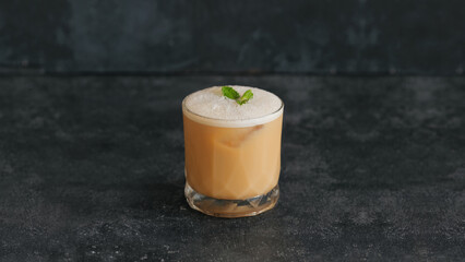 Refreshing Iced Coffee with Cream and Mint on a Dark Surface