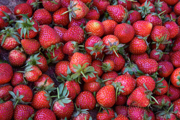 Fresh red strawberries piled together, showing vibrant color and texture. Close-up of ripe sweet strawberries, perfect for fruit, food, and healthy lifestyle concepts.