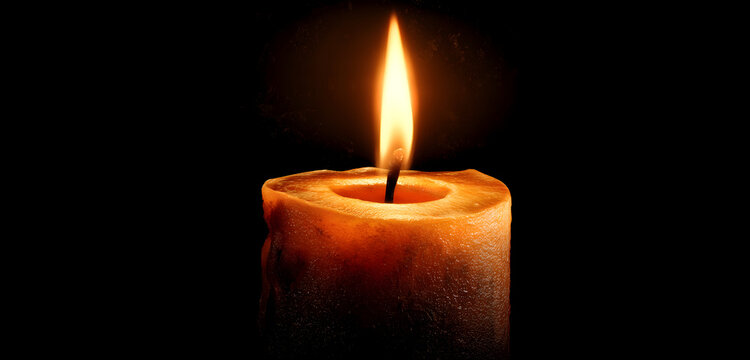 Warm candle flame glowing softly in the darkness, perfect for creating a cozy and relaxing atmosphere at home or adding a touch of elegance to any space