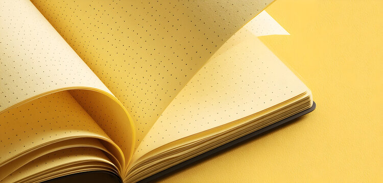 Golden open notebook with dotted pages invites creativity and journaling, perfect for planning, sketching, or capturing bright ideas on a sunny yellow surface