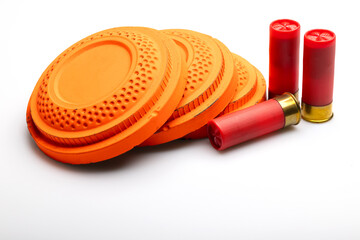 Clay shooting targets with shotgun shell bullets on white background © Suttiwan